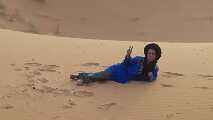 Uno dei due berberi posa per la foto sdraiato sulla sabbia